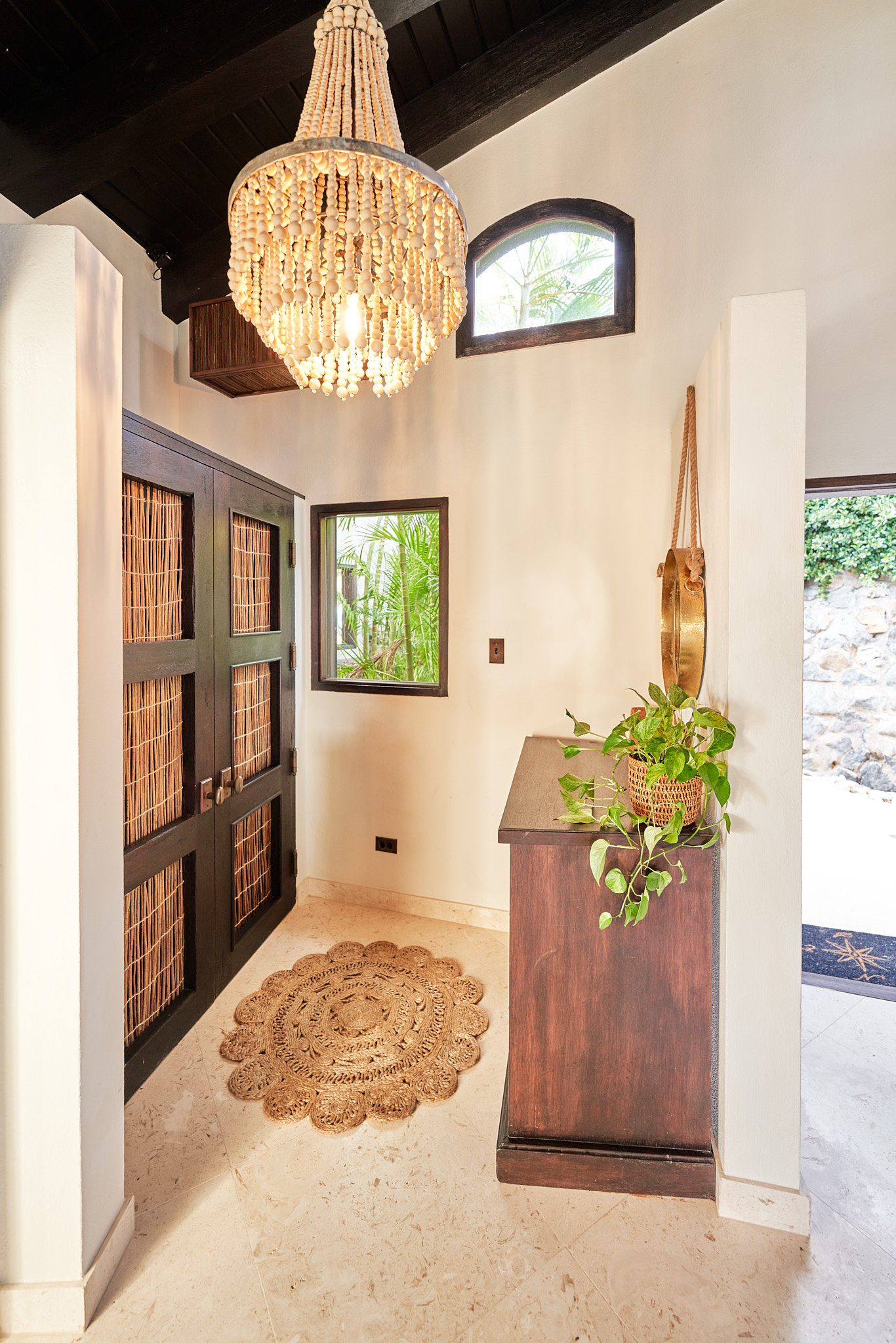 image Warm entry hallway with woven lighting and wood panel doors.