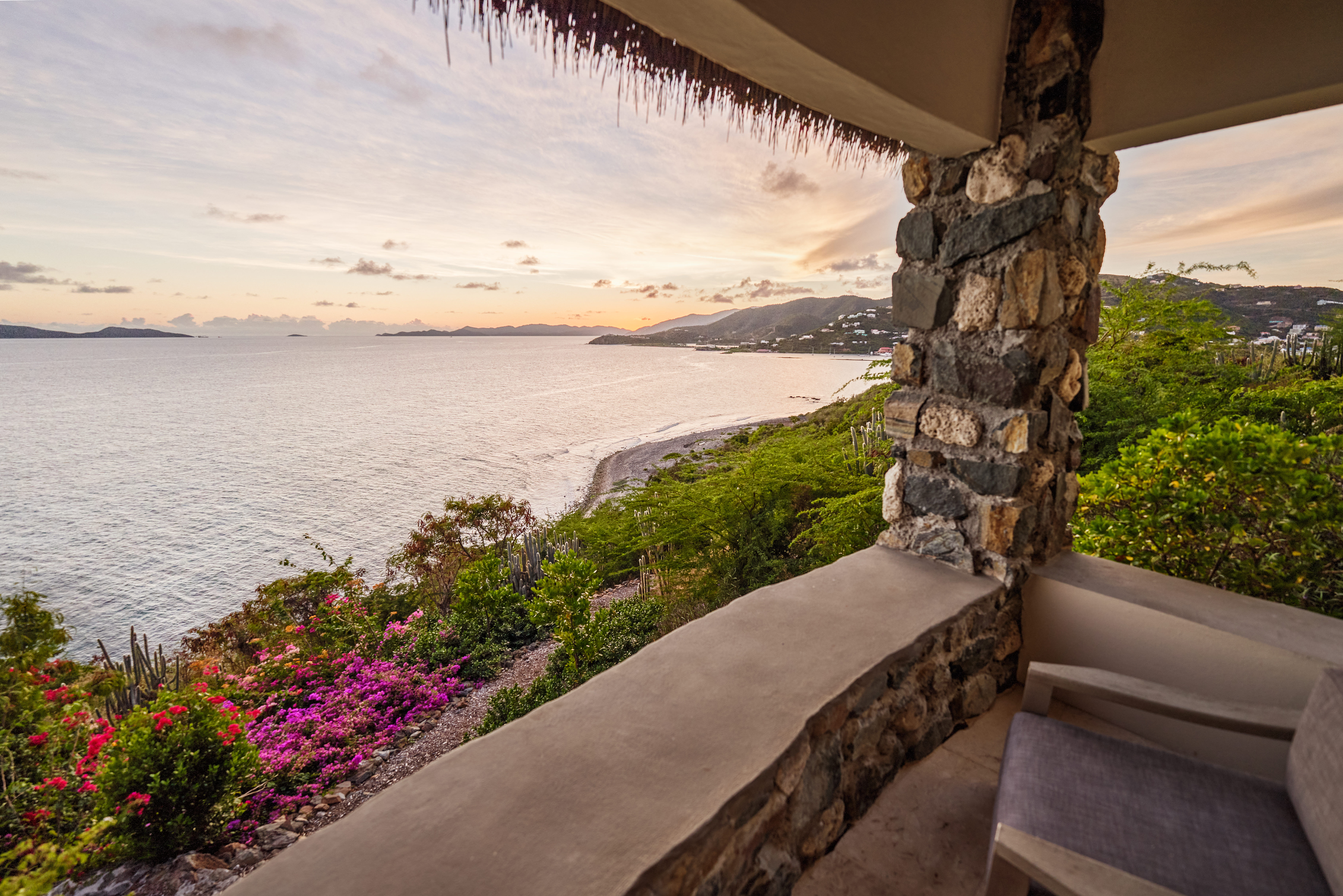 image Experience breathtaking 180º sunset ocean views from the cozy stone terrace of 'Grace', surrounded by vibrant tropical gardens.