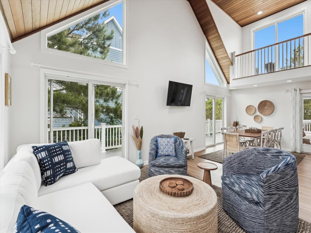 image Inviting living room with modern decor, plush seating, and wood beam accents filled with natural light.