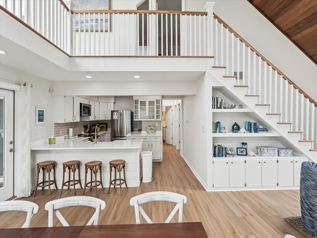 image Modern kitchen with white cabinetry, stainless steel appliances, and spacious island for entertaining.