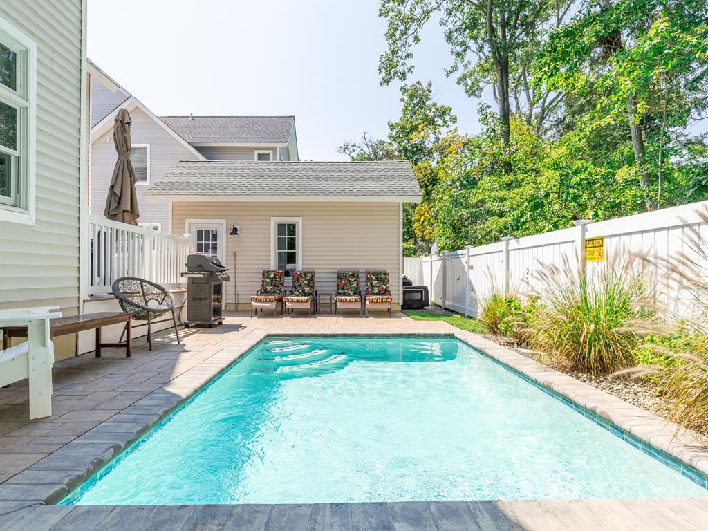 image Refresh in the private 12x18 inground pool, complete with poolside seating and surrounded by lush greenery.