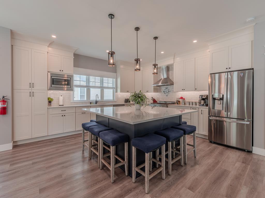 image Chef’s kitchen with a large center island and stainless steel appliances, ideal for entertaining.