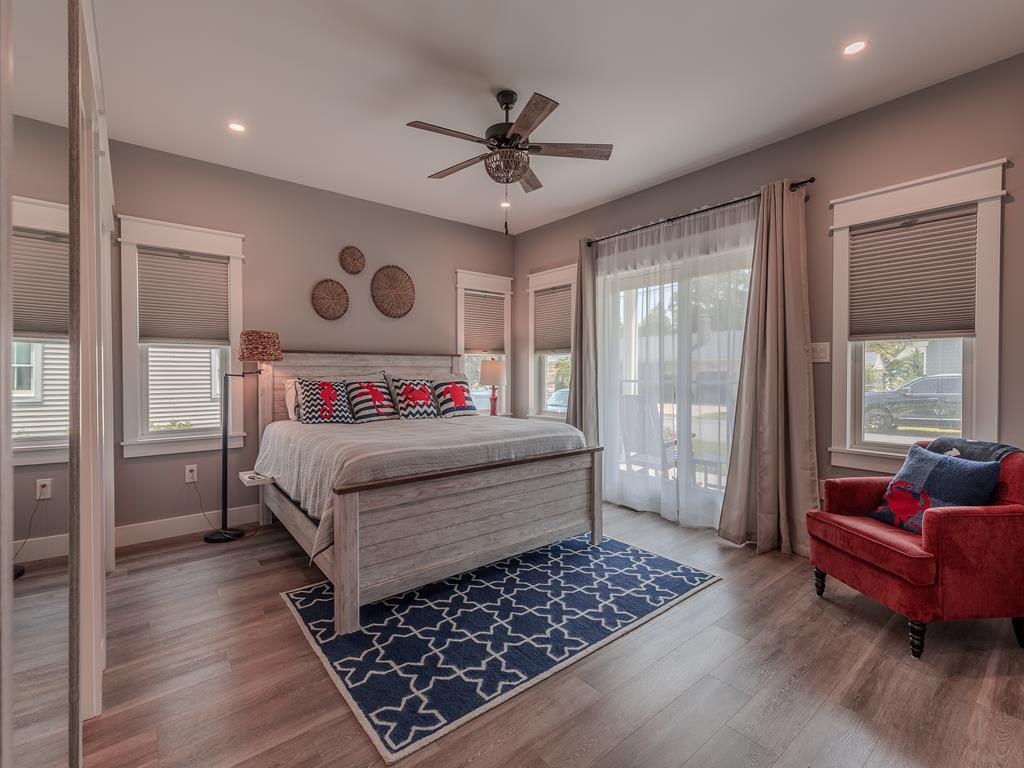 image Spacious second-floor master bedroom with king bed, seating area, and natural light galore.
