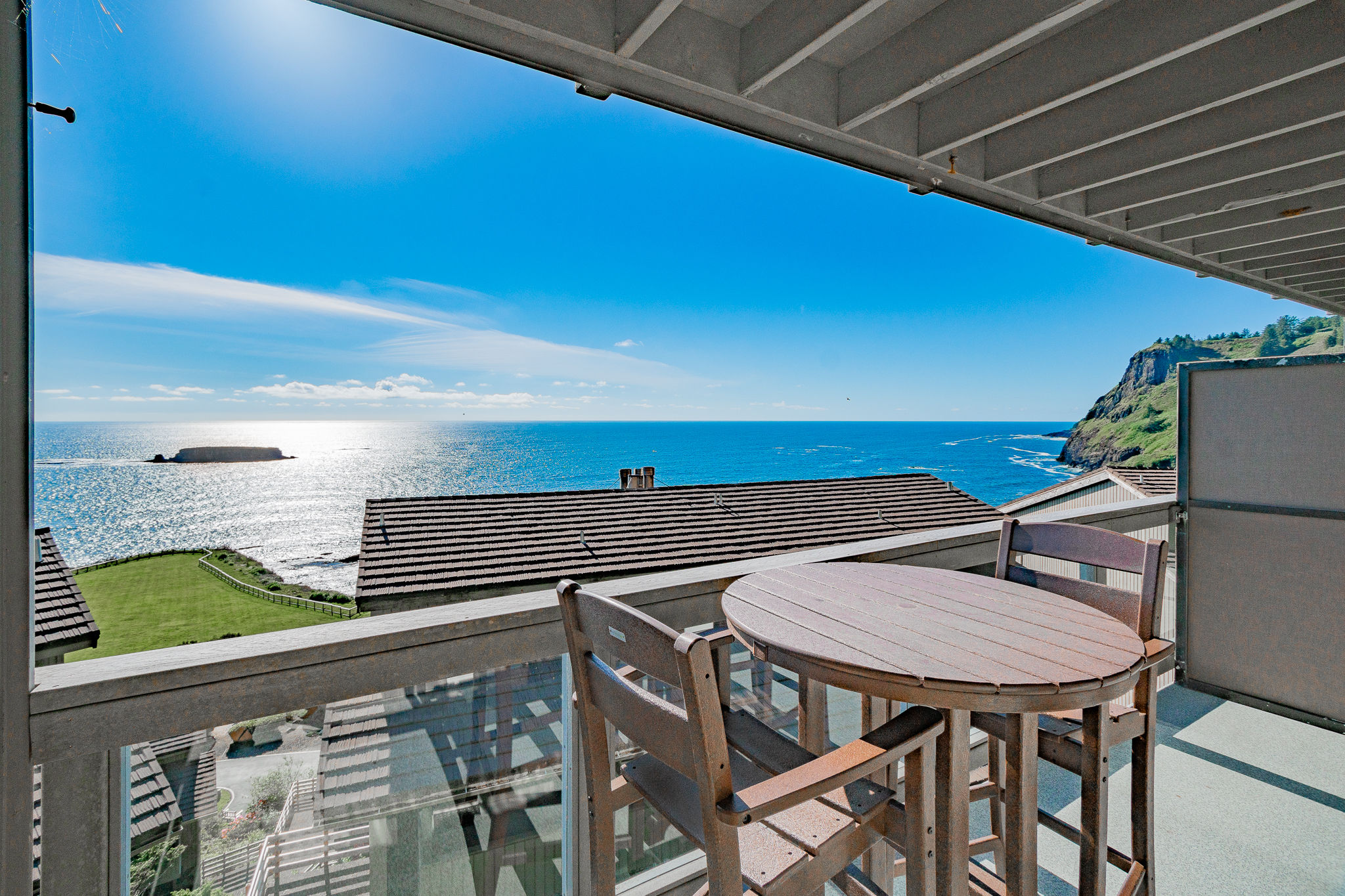 image Relax on your private balcony with ocean vistas subtly framed by nearby trees and buildings.
