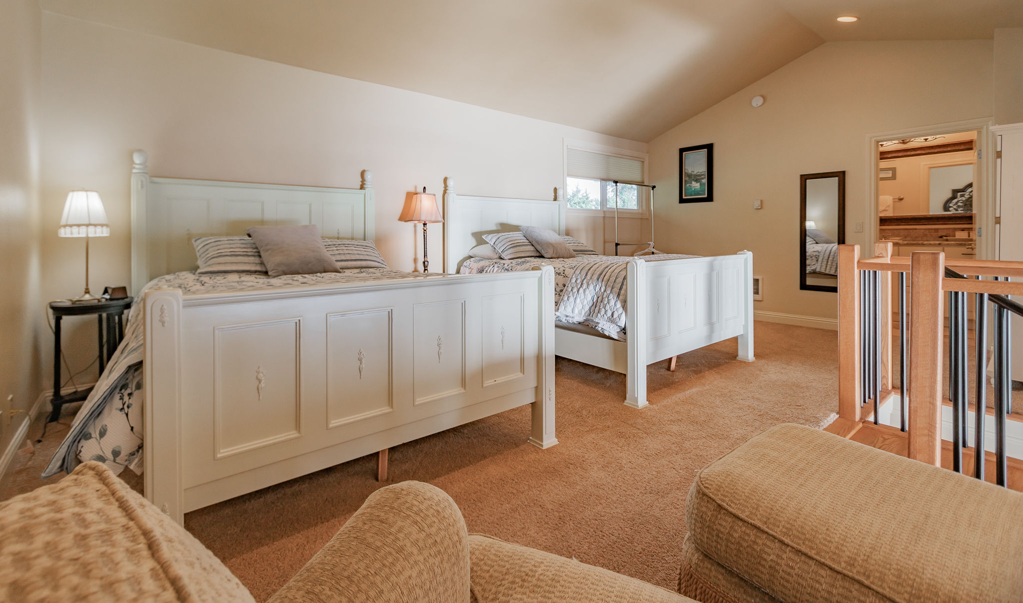 image Relax in the charming loft bedroom, which is elegantly furnished with two queen beds, ensuring comfortable accommodation for all guests.
