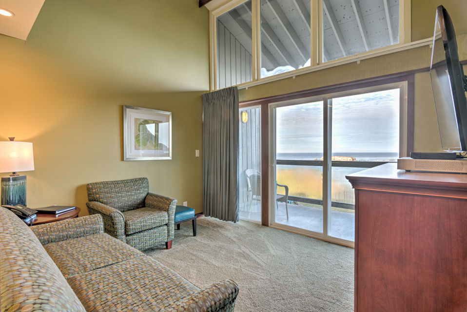 image This bright sitting area showcases panoramic ocean views through expansive windows, with comfortable seating perfect for relaxation.