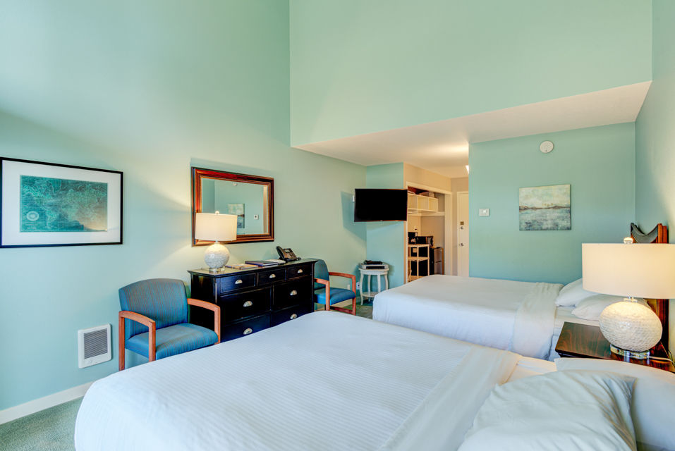 image Designed for relaxation, this room includes two queen beds, a comfortable sitting area, and a well-equipped kitchenette, perfect for a restful getaway in nature.