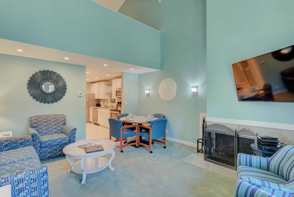 image This inviting living area showcases a loft-style layout with stylish seating, a dining area, a full kitchen, and a charming fireplace.