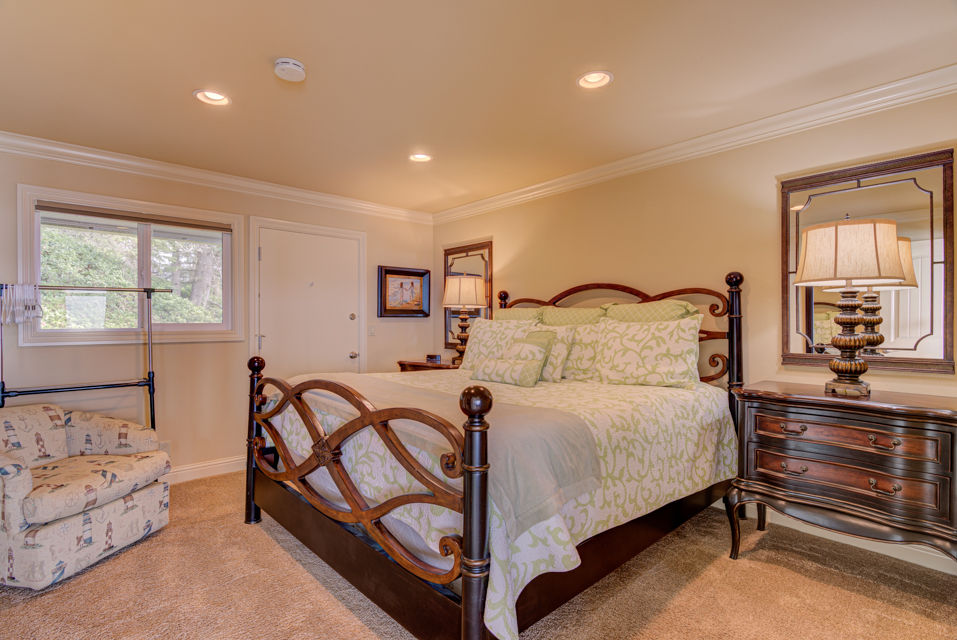 image Relax in the elegantly decorated king bedroom that features ample natural light and a serene ambiance, making it a perfect retreat.