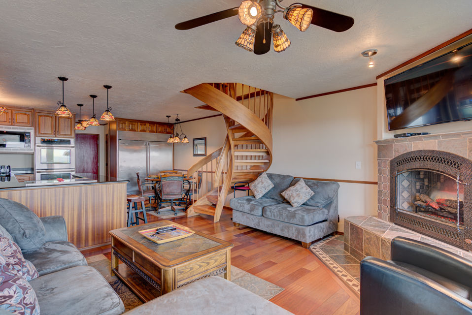 image The Gathering Place features a spacious living room with a cozy sectional sofa, a beautiful spiral staircase leading to the upper level, and a gourmet kitchen equipped for delightful meals.
