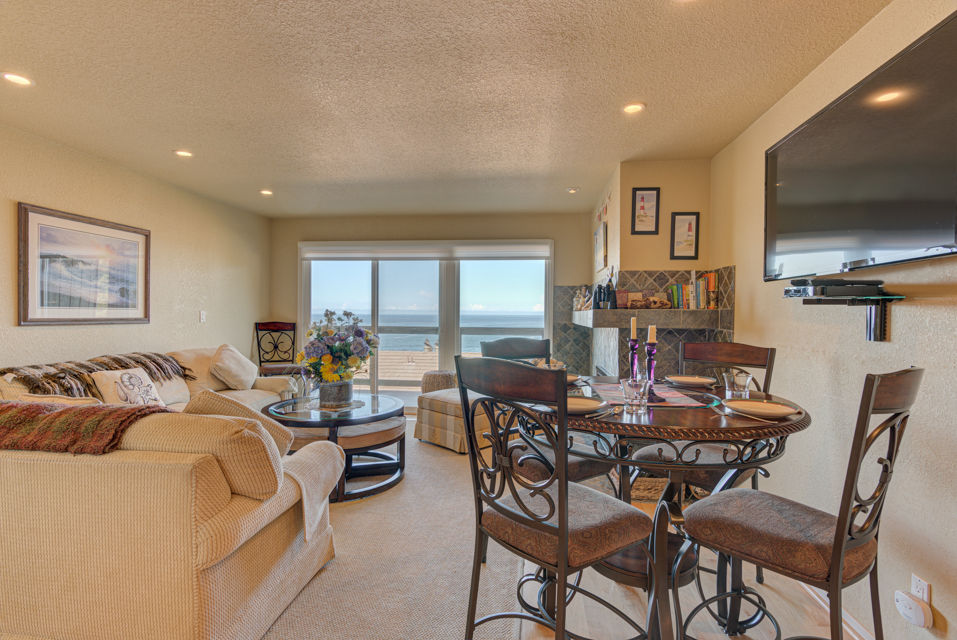 image Bright and airy, the dining area adjacent to the living room features a circular table, perfect for enjoying meals while gazing at the stunning ocean views outside.