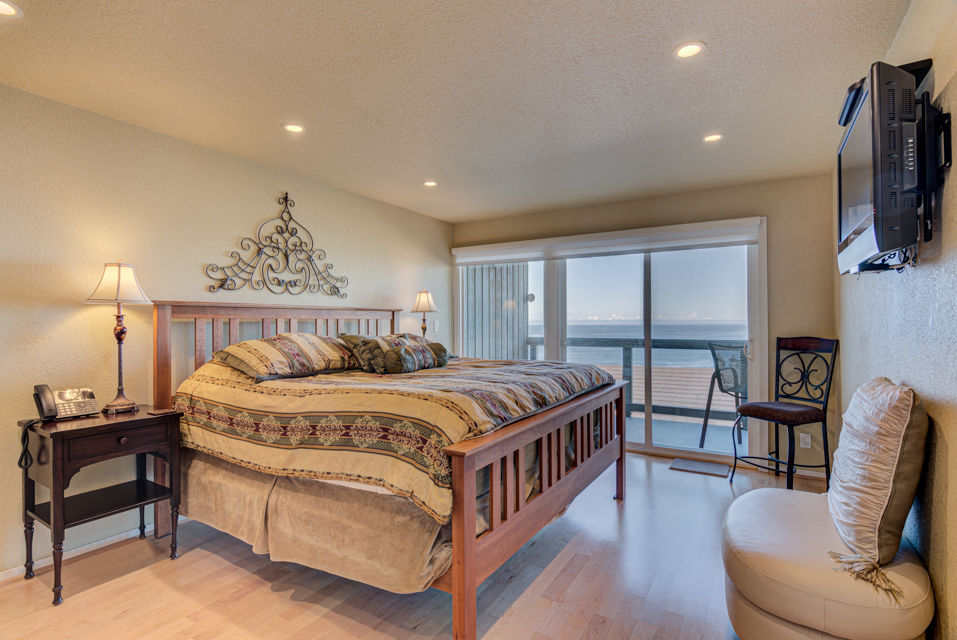 image The spacious king bedroom features a comfortable bed, elegant decor, and a private ocean-view balcony that brings the beauty of the sea right into your personal retreat.