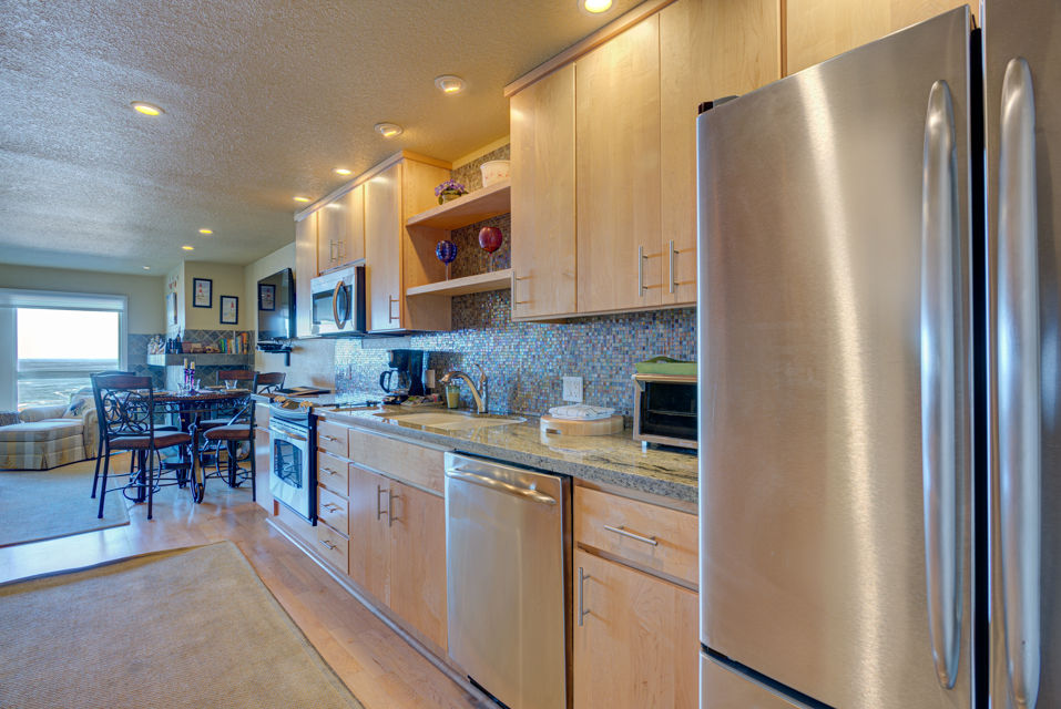 image This full kitchen is equipped with modern appliances, including a stainless steel refrigerator and ample counter space, making meal preparation a breeze during your stay.