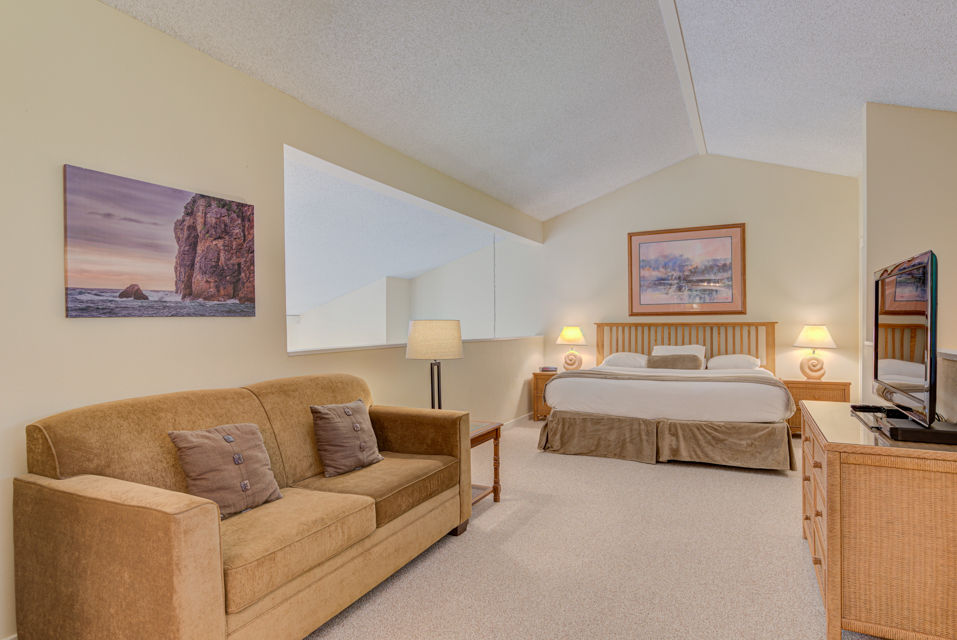 image The spacious loft features a comfortable king bed, complemented by a stylish living area with a cozy couch and beautiful wall art.