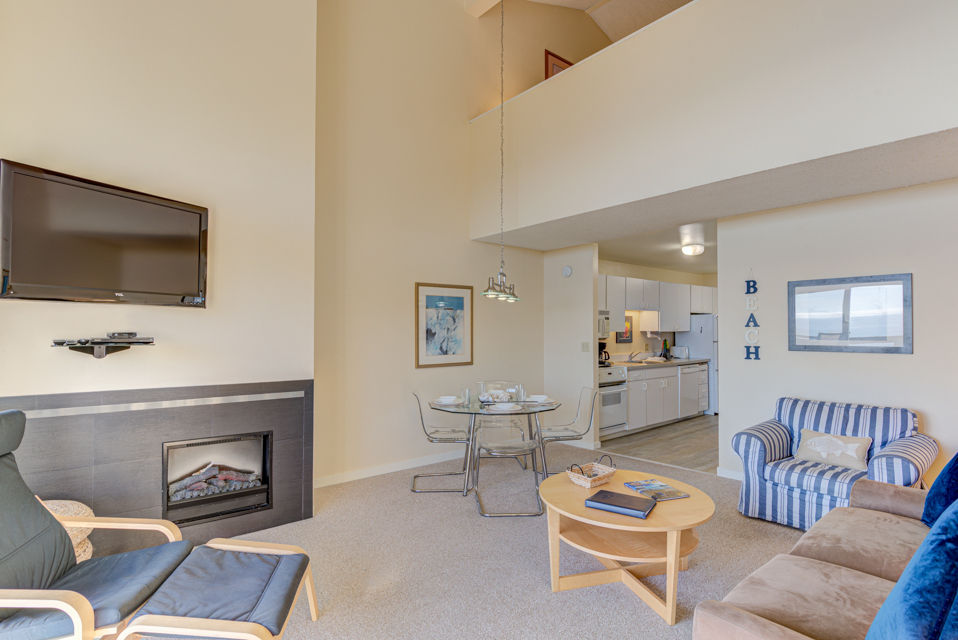 image Elevate your experience in the airy living area, showcasing a flat-screen TV, a dining table, and an inviting ambiance with panoramic ocean views.