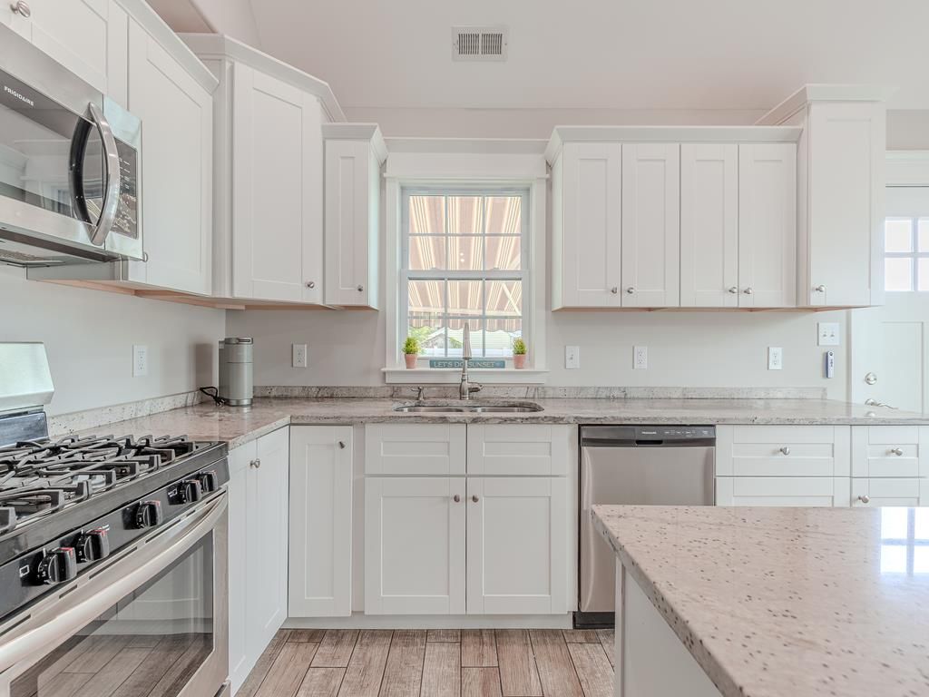 image Gas stove and full-size microwave make meal prep effortless in this beautifully updated kitchen.