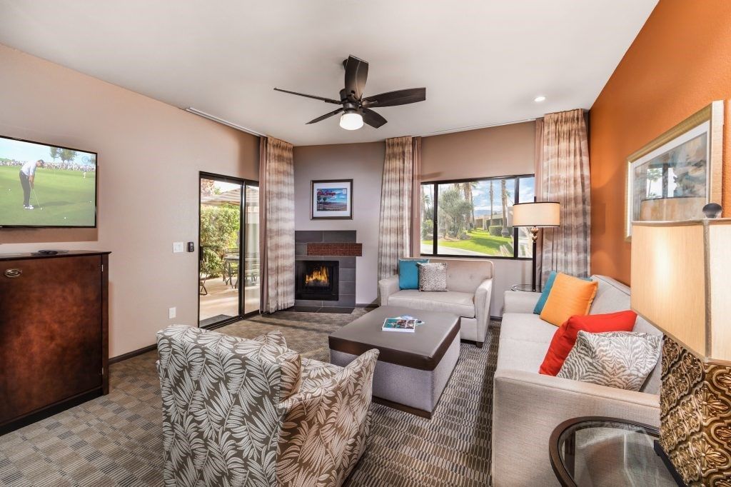 image The cozy living room features modern furnishings, a flat-screen TV, and a fireplace, providing a welcoming atmosphere with views of the lush outdoors.
