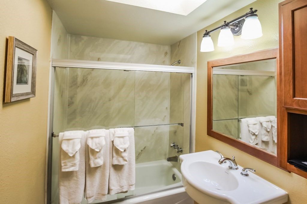 image This stylish bathroom combines functionality and elegance, featuring plush towels, a glass shower, and warm lighting that invites a soothing escape.