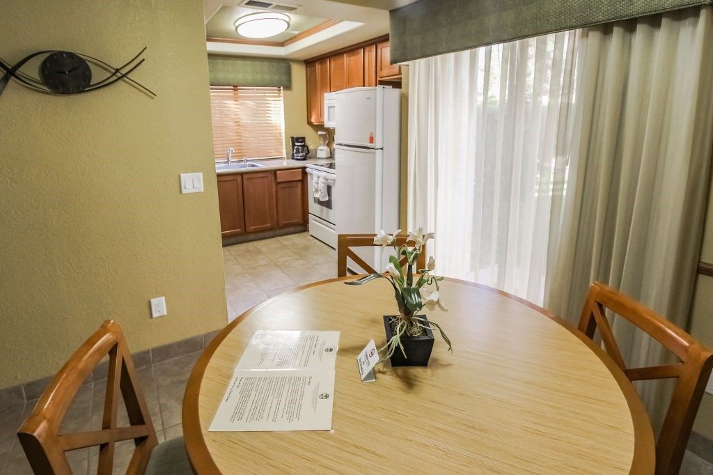 image The well-appointed kitchen, complete with modern appliances and ample counter space, flows seamlessly into a bright dining area, perfect for family meals.