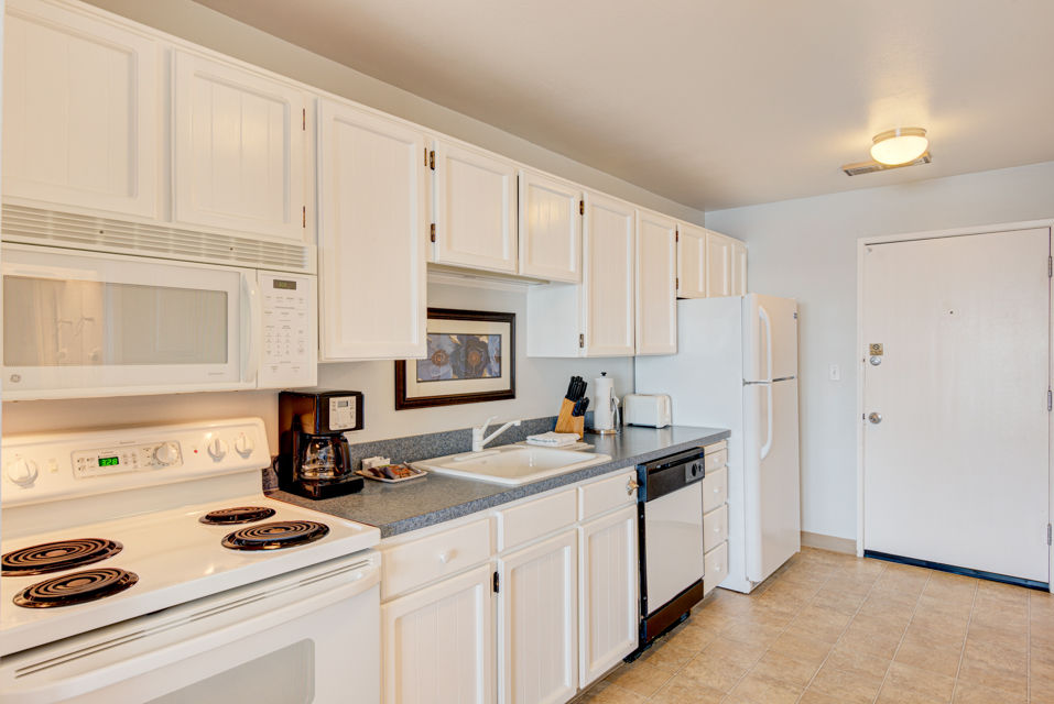 image Bright and airy, the fully equipped kitchen offers easy access to the dining area and panoramic ocean views, making it an ideal space for a cozy meal or snack.