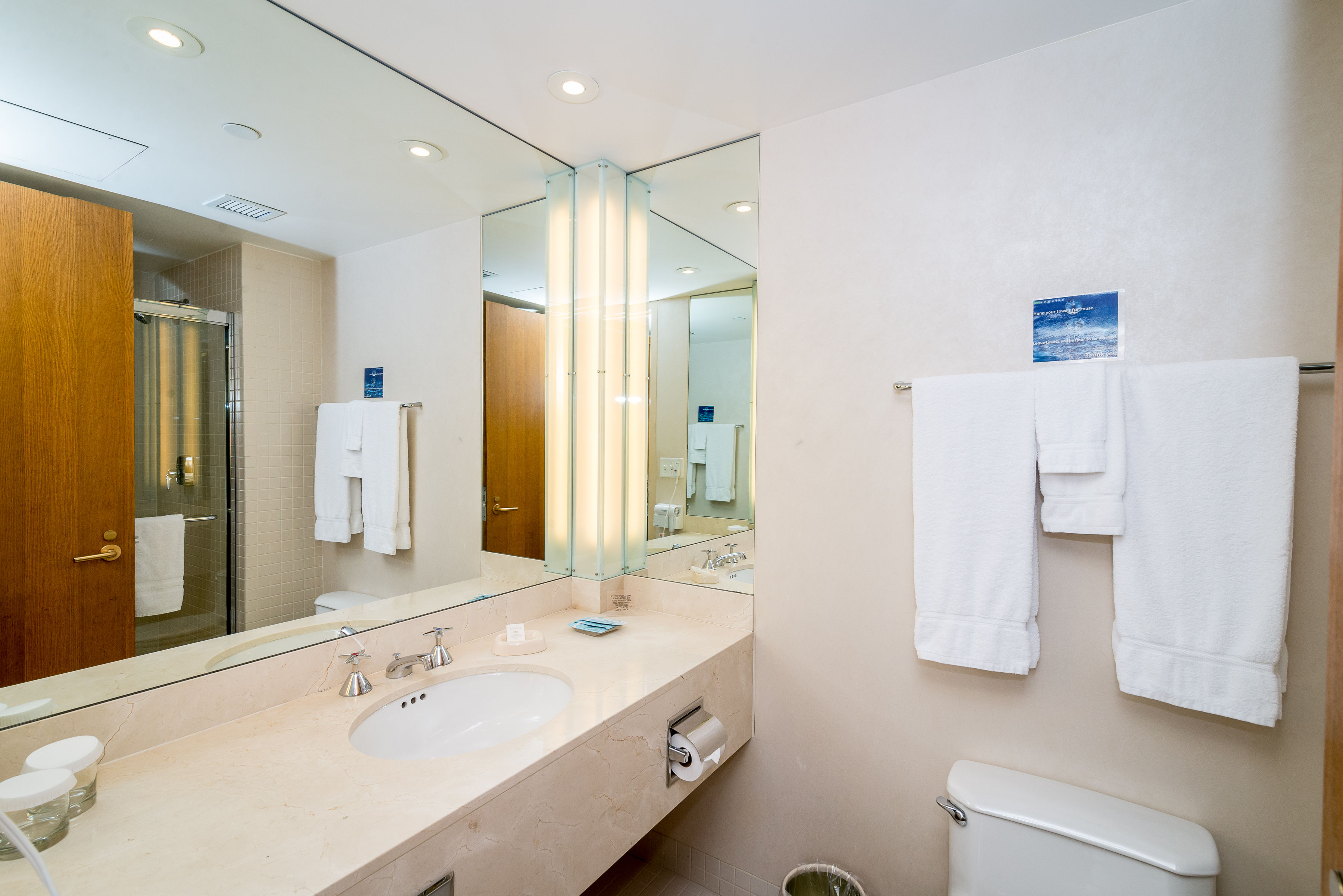 image Refresh in the bright, airy bathroom with modern fixtures, including a spacious vanity, plush towels, and an inviting shower, ensuring a relaxing experience during your visit.