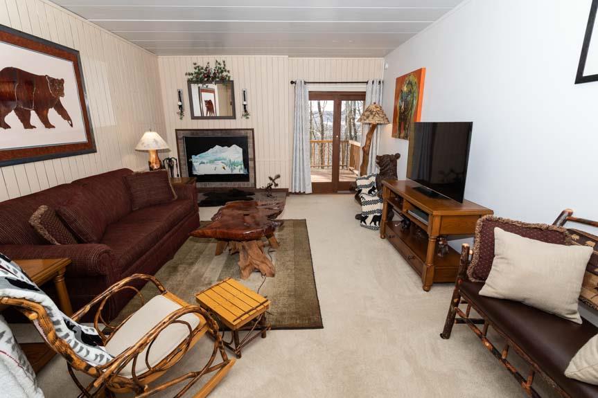image The cozy living room offers a comfortable couch, stylish furniture, and a large TV, framed by warm decor and a window that invites natural light.