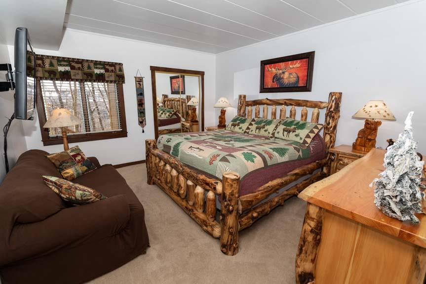 image This cozy bedroom showcases a beautifully crafted log bed, charming decor, and a comfortable space for relaxation.