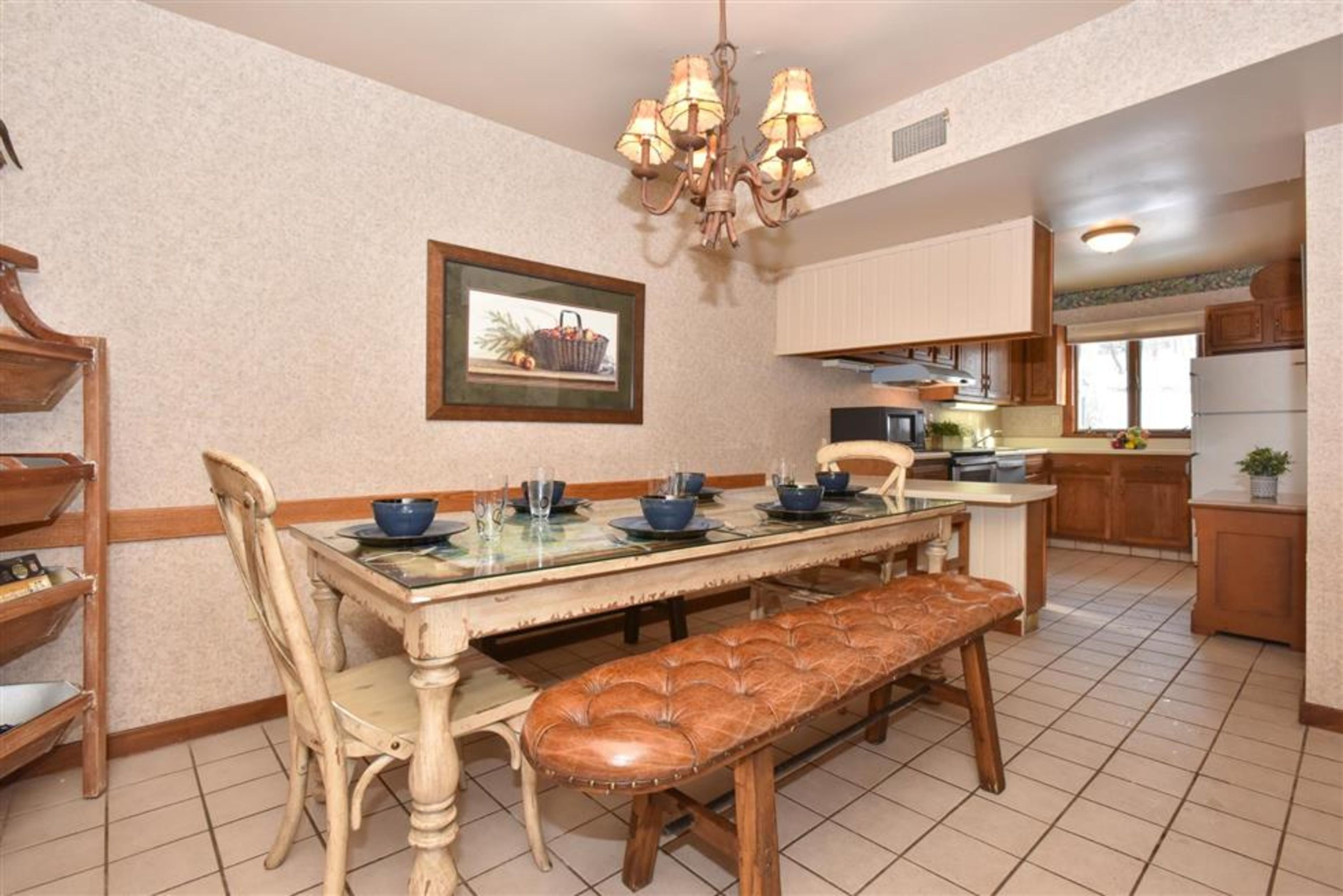 image The inviting dining area is beautifully set with tableware and a stylish chandelier, perfect for family meals and gatherings.