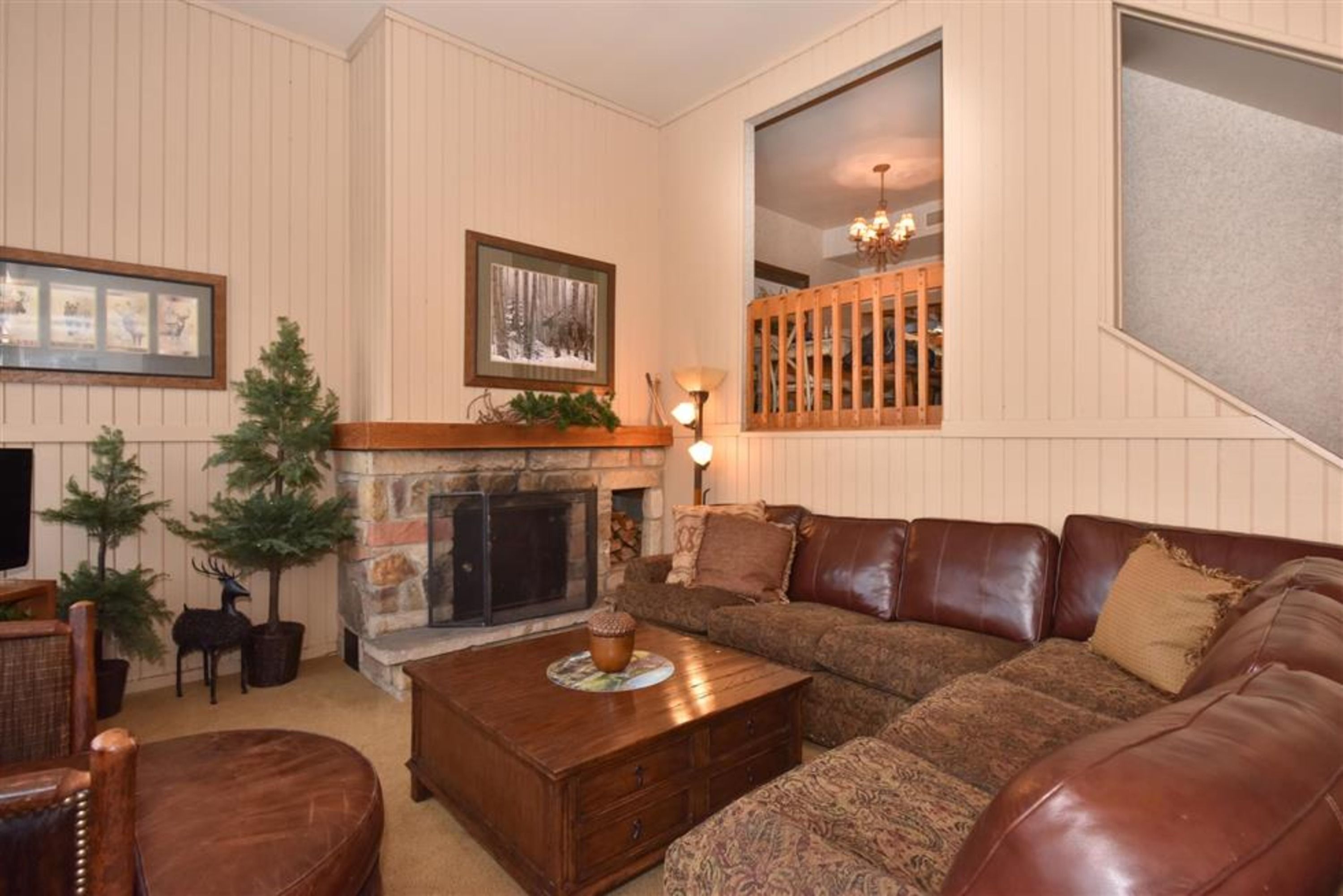 image The cozy living room features a plush sectional sofa, a stone fireplace, and charming decorative accents that create a welcoming retreat.