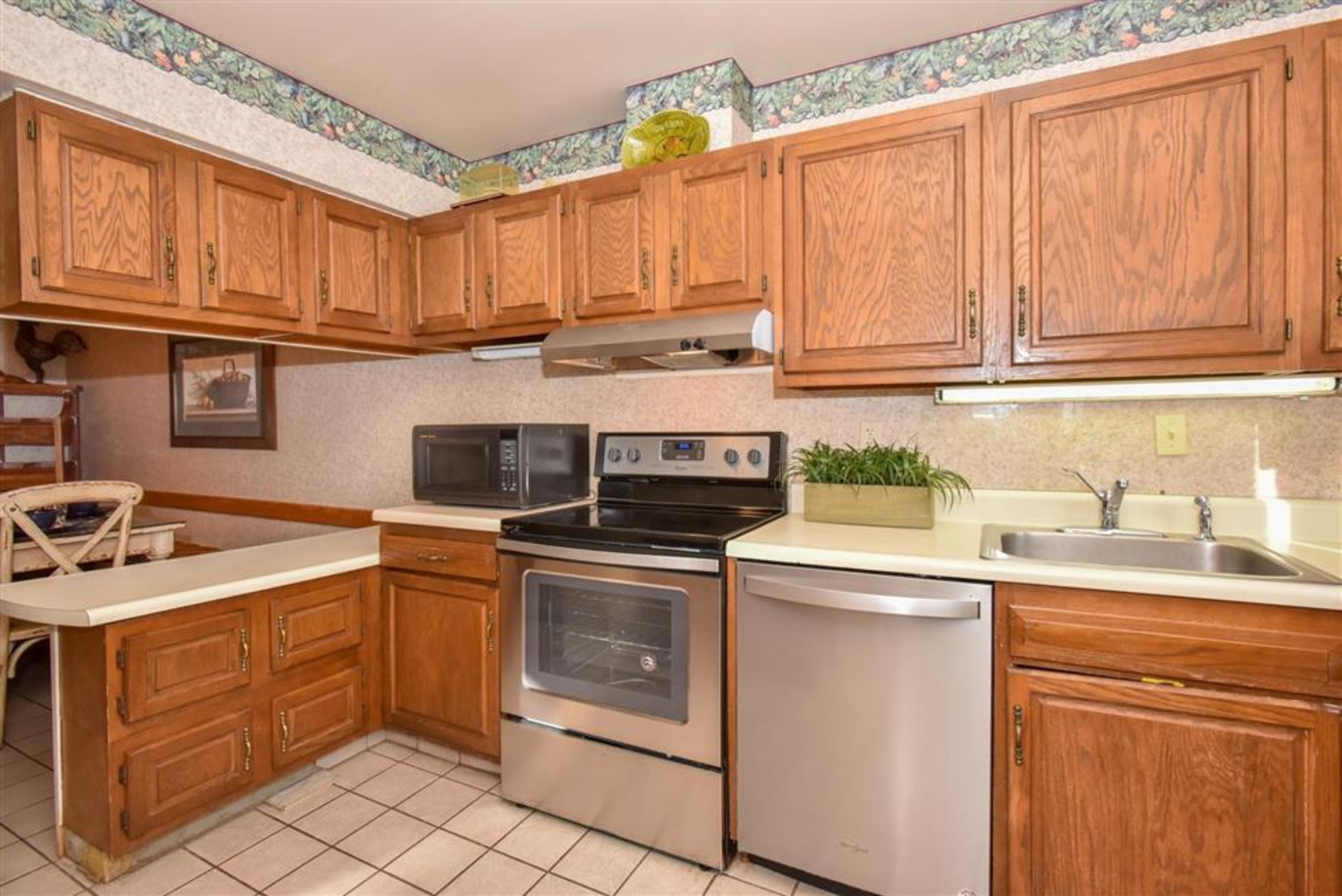 image This well-equipped kitchen boasts attractive wood cabinetry, modern appliances, and ample counter space for meal preparation.