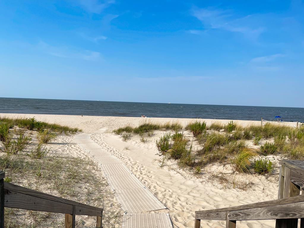 image Sandy shoreline and sparkling waves await your arrival.