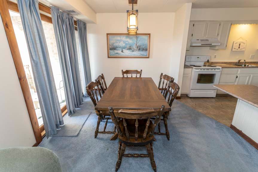 image The dining area features a large wooden table surrounded by chairs, offering a perfect gathering spot for meals and conversation.