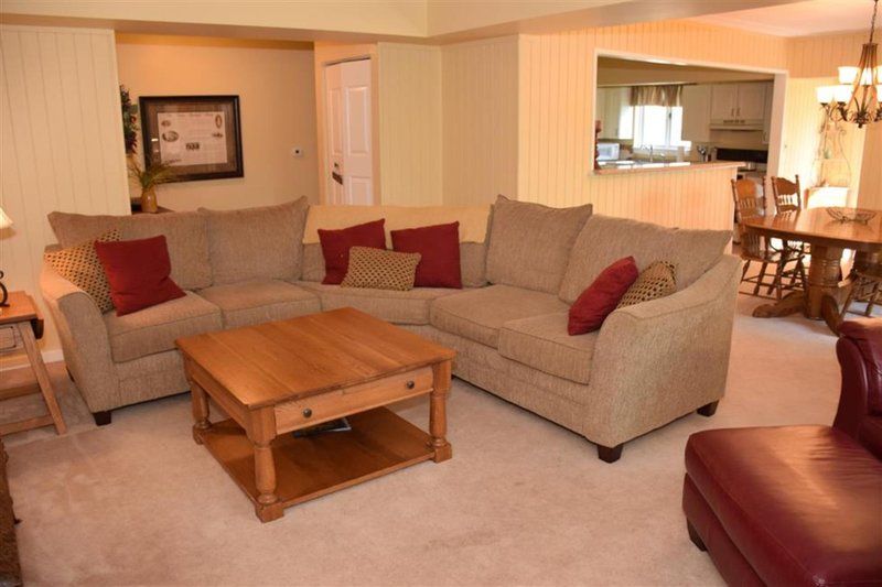 image The cozy living area showcases a spacious sectional sofa adorned with decorative cushions, inviting relaxation and comfort.
