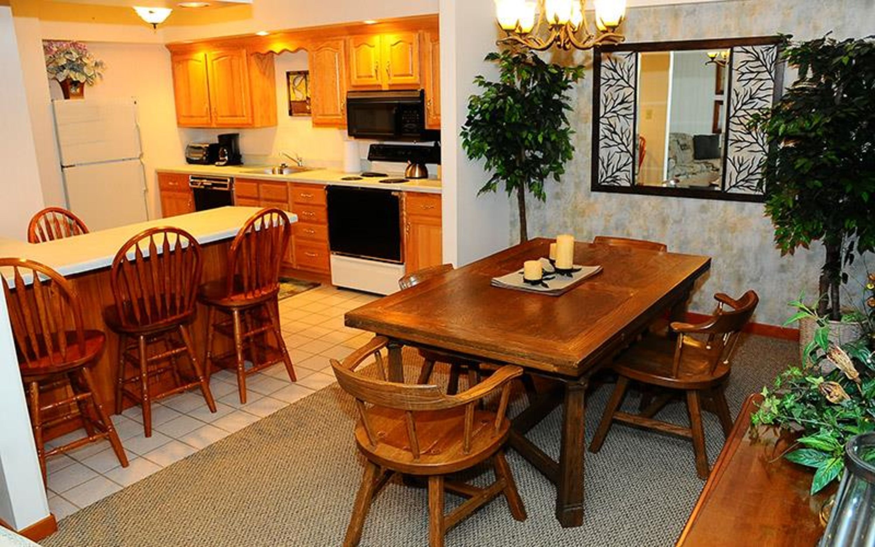 image An open-plan kitchen and dining space highlighted by rich wood tones and a rustic dining table, creating an inviting atmosphere for meals.