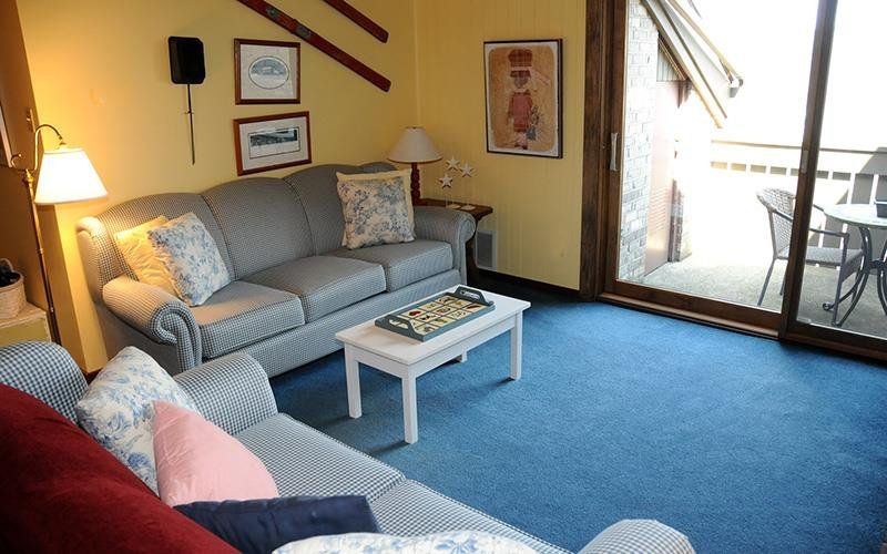 image The cozy living room features comfortable seating, a coffee table, and large windows that let in natural light.