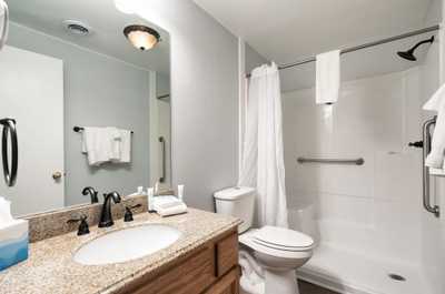Spacious bathroom with granite vanity, full tub, and bright lighting for a fresh start.