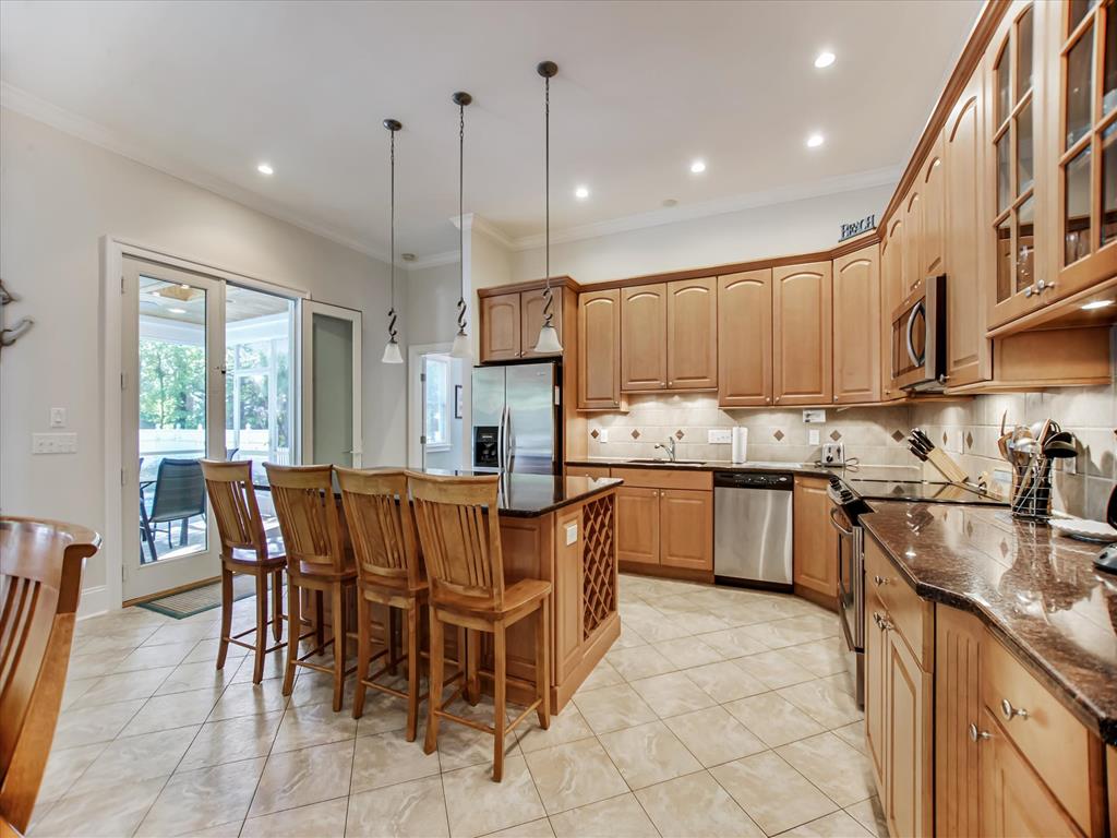 image Alternate kitchen view showcases generous prep space, pendant lighting, and seating that accommodates larger gatherings.