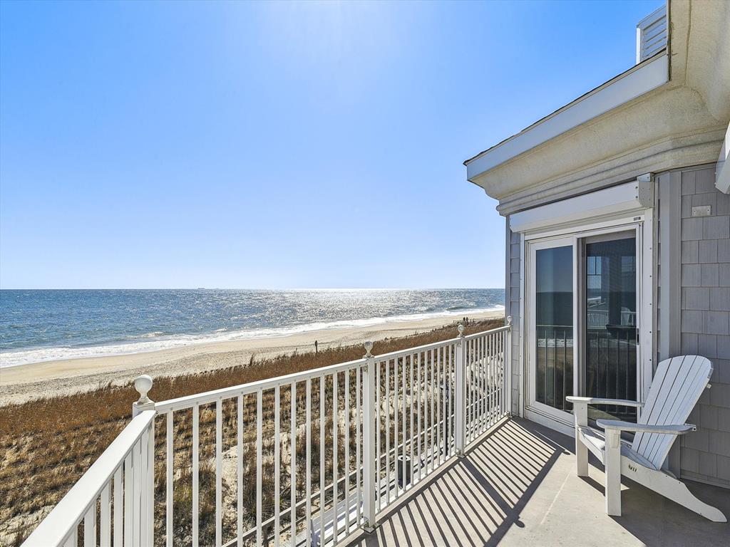 image With its expansive oceanfront views and inviting seating, this sunlit terrace is an ideal spot for sunbathing or enjoying captivating sunsets over the tranquil Delaware coastline.