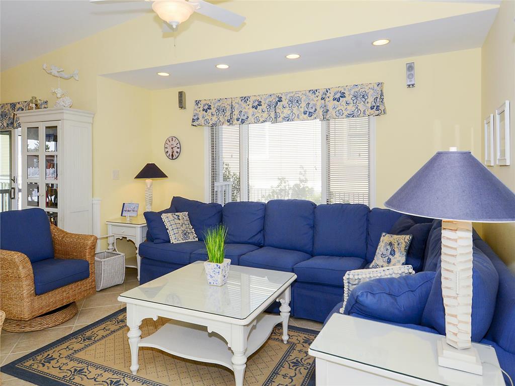 image The cozy living area features a bright and cheerful yellow wall complemented by a charming blue sectional sofa and nautical-themed decor.