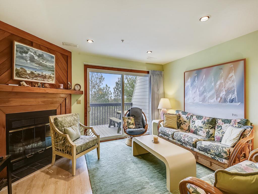 image Inviting living room with fireplace and deck access—perfect for movie nights with cable/DVD.