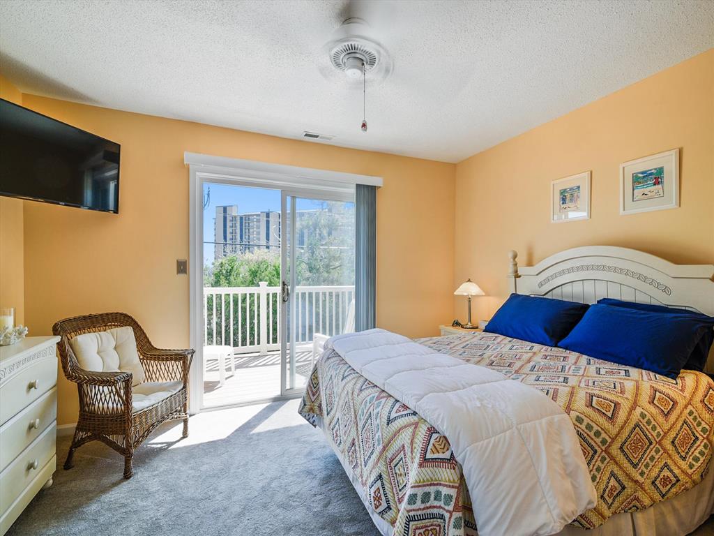 image Relax in a cozy retreat with a plush bed and soft light from the private deck doors.