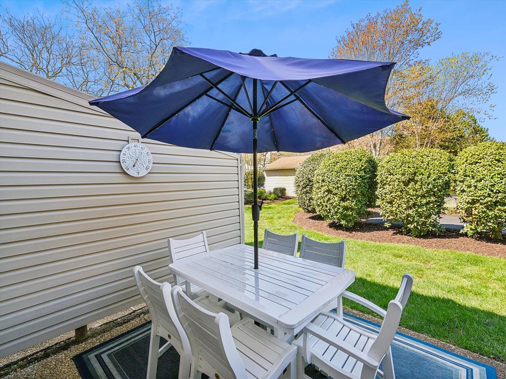 image Gather around the table beneath the umbrella for al fresco dining or morning coffee.