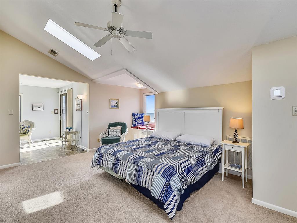 image Bright and airy master bedroom with plenty of space to relax after a day in the sun.