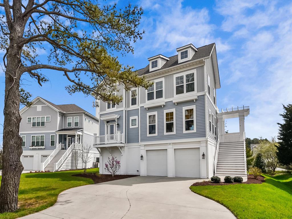 image Experience coastal elegance with this stunning home featuring classic architecture against a vibrant blue sky.