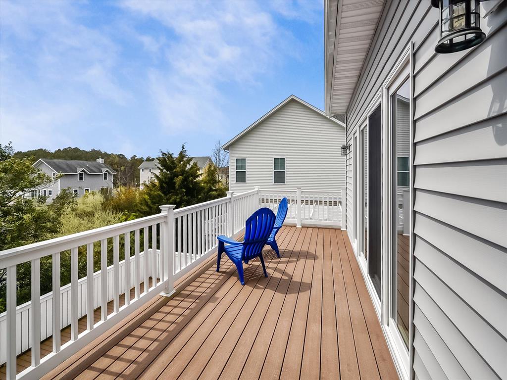 image Relax on the spacious deck, soaking up the sun in comfortable outdoor chairs.
