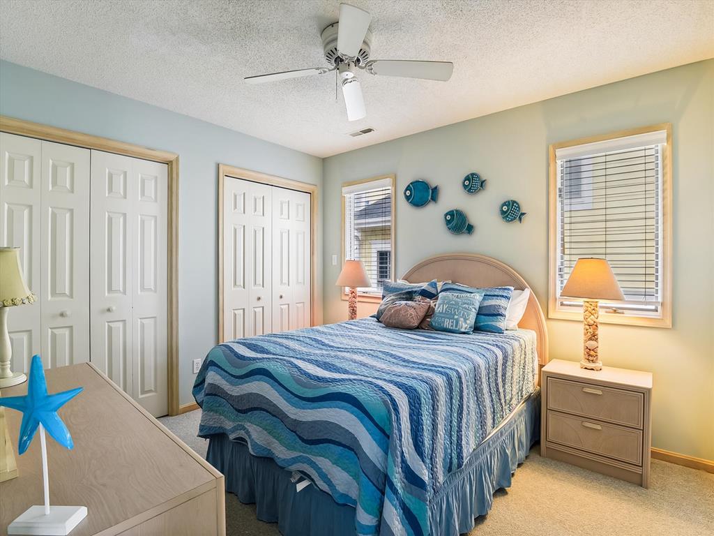 image Rest easy in this vibrant bedroom, complete with coastal decor and cozy bedding, inviting relaxation after a day of adventures.