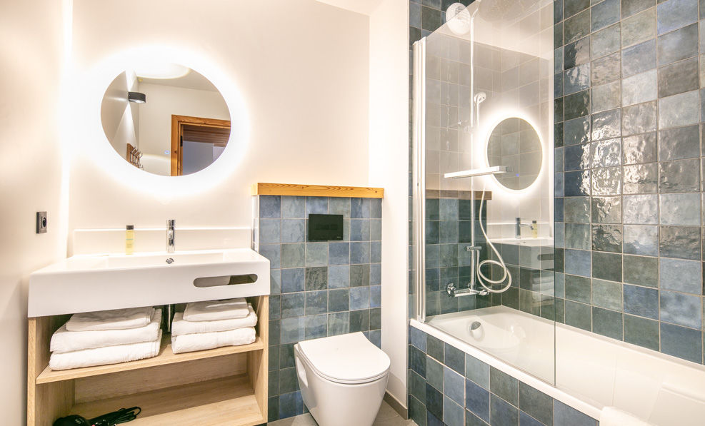 image The modern bathroom in the Vaujany studio features a sleek design with stylish tilework, illuminated mirror, and a glass-enclosed shower, enhancing the overall contemporary feel of this cozy retreat.