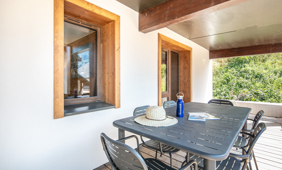 image The spacious balcony is furnished with a large table, perfect for enjoying meals outdoors in the scenic surroundings.