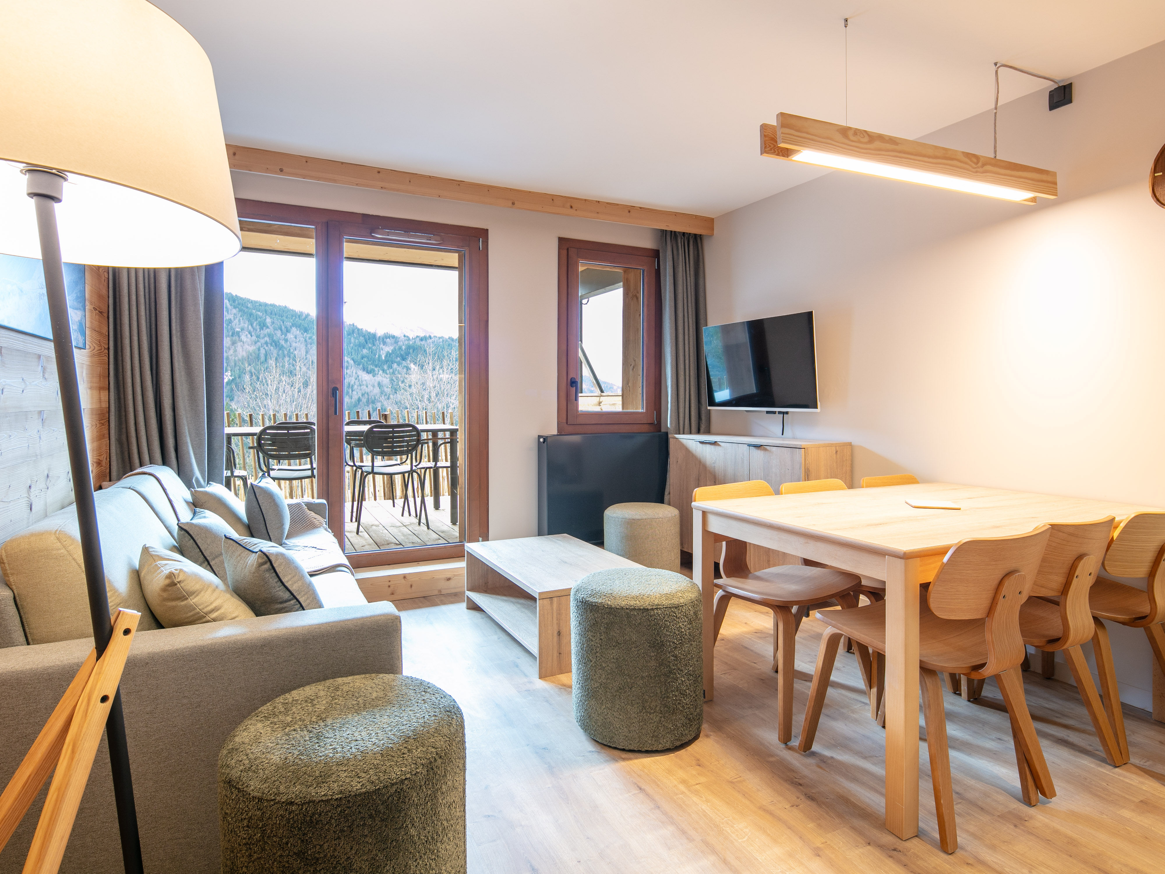 image Gather around the modern dining table for meals, while the large windows flood the space with natural light.