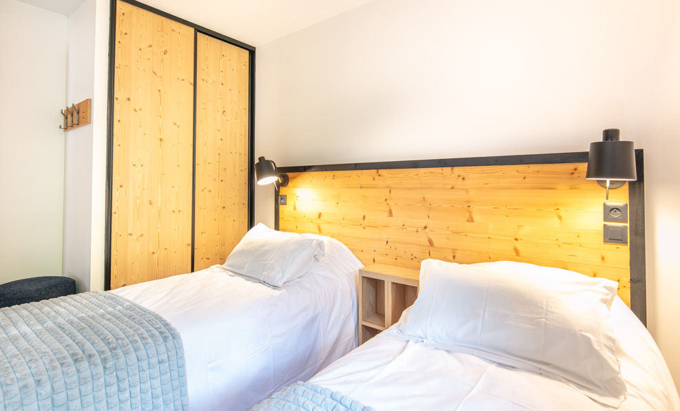 image The bedroom offers twin beds adorned with soft linens and warm lighting, providing a peaceful retreat for guests.
